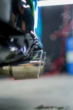 Foto de Primer plano del tubo de escape que emite humo de un coche de lujo de color camaleón en proceso de lavado de automóviles - Imagen libre de derechos