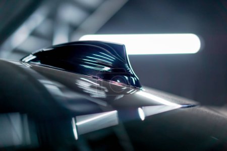 Téléchargez les photos : Gros plan de l'antenne radio d'une voiture de luxe recouverte d'un film de chamelion au lavage de la voiture en cours de détail - en image libre de droit