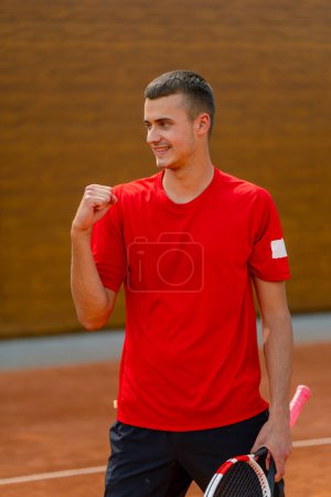 Foto de Retrato de un joven jugador de tenis profesional se regocija por la victoria en la competición del torneo en el juego deportivo ganador de pista abierta - Imagen libre de derechos