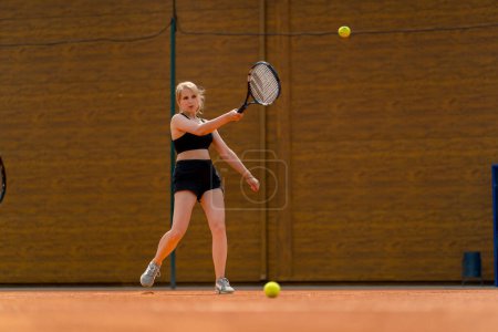 Foto de Una joven tenista golpea emocionalmente la pelota servir de su oponente jugar al tenis en la competencia de pista cubierta - Imagen libre de derechos