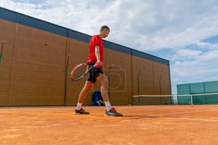 Foto de Joven entrenador jugador profesional pista de tenis al aire libre practicar golpes con raqueta y pelota de tenis jugando contra el oponente - Imagen libre de derechos