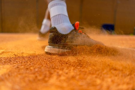 Téléchargez les photos : Gros plan du pied d'un joueur de tennis ou d'un instructeur sur un terrain extérieur poussière de sol s'élevant près de la chaussure - en image libre de droit