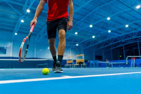 Photo for Professional player coach standing in indoor tennis court front background small ball big sport training - Royalty Free Image