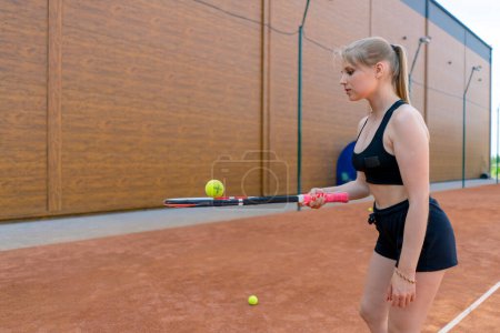 Téléchargez les photos : Jeune fille débutant joueur de tennis frappe la balle avec une raquette sur les trains de court et apprend à frapper servir passe-temps sportif - en image libre de droit