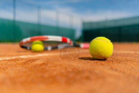 Foto de Primer plano de los equipos deportivos, raquetas de tenis y pelotas se encuentran una cancha de tierra al aire libre hobby deporte de competición - Imagen libre de derechos