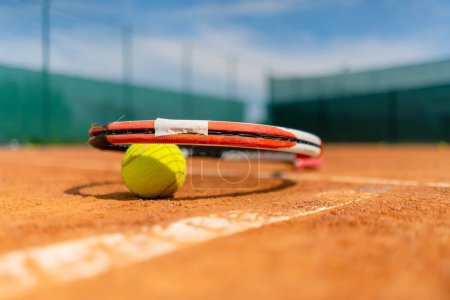 Foto de Primer plano de los equipos deportivos, raquetas de tenis y pelotas se encuentran una cancha de tierra al aire libre hobby deporte de competición - Imagen libre de derechos