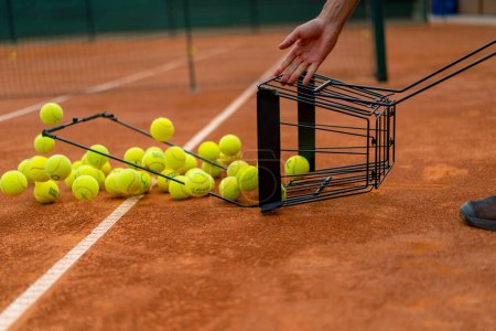 Foto de Primer plano de muchas pelotas de tenis que caen de la canasta de arcilla pista de tenis deporte entrenamiento de competición - Imagen libre de derechos