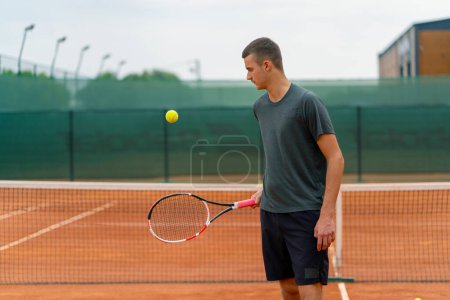 Téléchargez les photos : Jeune entraîneur de joueur de tennis frappant la balle avec une raquette sur le court de tennis se préparant pour le mode de vie sportif de compétition - en image libre de droit