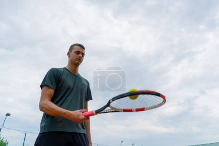 Téléchargez les photos : Jeune entraîneur de joueur de tennis frappant la balle avec une raquette sur le court de tennis se préparant pour le mode de vie sportif de compétition - en image libre de droit