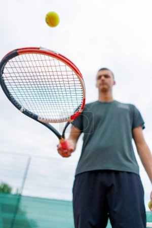 Téléchargez les photos : Gros plan jeune entraîneur de joueur de tennis frappant la balle avec une raquette sur le court de tennis se préparant pour le mode de vie sportif de compétition - en image libre de droit