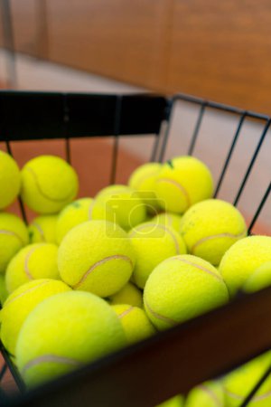 Foto de Primer plano de muchas pelotas de tenis que yacen en una canasta en la cancha de deportes de entrenamiento de competición - Imagen libre de derechos
