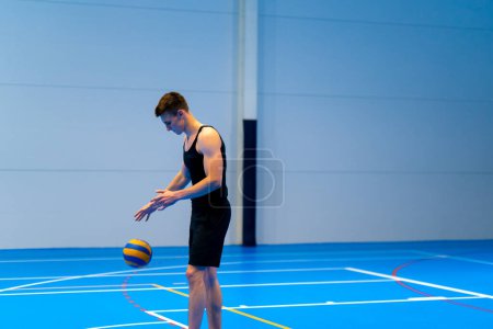Foto de Joven bombeado chico deportista se prepara para servir a la pelota durante el partido de voleibol o partido - Imagen libre de derechos