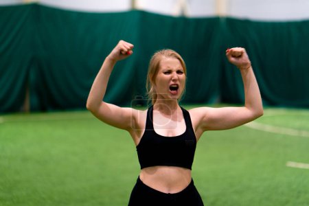 Photo for Women's football young girl rejoices on the football field after scoring goal against the opponent's goal sports game - Royalty Free Image