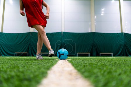 Photo for Close-up of a soccer player's foot kicking the ball for a penalty or a goal or passing a ball on green synthetic grass during football game - Royalty Free Image