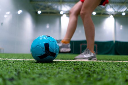 Photo for Close-up of a soccer player's foot kicking the ball for a penalty or a goal or passing a ball on green synthetic grass during football game - Royalty Free Image