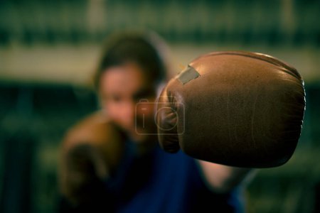Foto de Mujer en guantes de boxeo posando en una pelea descarada y competitiva en un ring de boxeo antes de una pelea con el oponente de cerca - Imagen libre de derechos