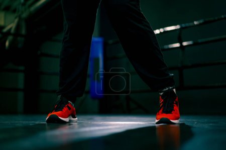 Foto de Piernas fuertes de una deportista en un puesto en una estera en la lucha libre de la competición del deporte del anillo de boxeo - Imagen libre de derechos