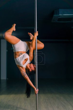 Photo for Flexible girl doing gymnastic exercises on pole for stretching Beautiful sexy woman showing body Pole dance sport - Royalty Free Image