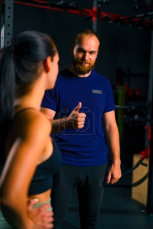 Photo for The trainer in the gym praises the girl athlete after a successful workout motivates her succeed in sports - Royalty Free Image