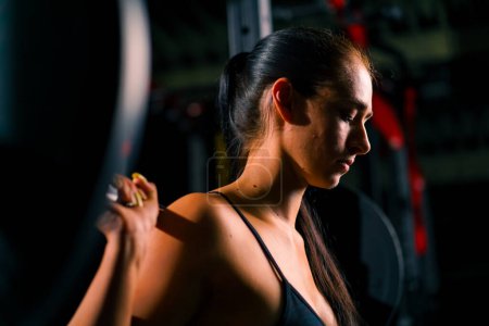 Photo for Portrait of young beautiful focused fitness woman doing heavy shoulder press exercise with barbell gym training muscle groups - Royalty Free Image