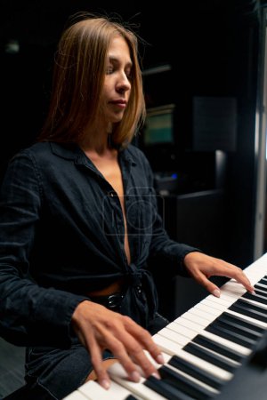 Téléchargez les photos : Pianiste préparant un concert et jouant une mélodie lyrique sur les touches du piano dans un studio de musique - en image libre de droit