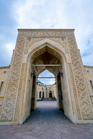 Photo for Beautiful cosy entrance to a Muslim mosque surrounded by an arch with Islamic ornaments against the blue sky - Royalty Free Image
