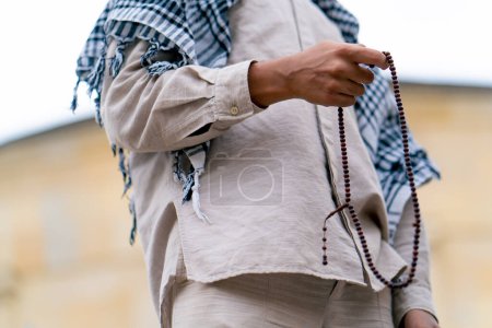 Photo for Male hands of an Islamic man holding a rosary during prayer of conversion and worship of Allah - Royalty Free Image