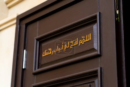 Téléchargez les photos : Une inscription en hiéroglyphes arabes sur la porte à l'entrée de la mosquée avec un appel à Allah d'être miséricordieux envers une personne qui prie - en image libre de droit