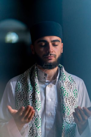 Téléchargez les photos : Portrait d'un musulman priant à genoux au Ramadan et rendant grâce pour le soutien et le bien-être spirituel dans la mosquée - en image libre de droit
