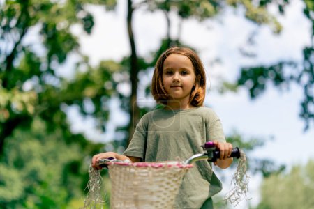 Foto de Retrato de una niña montando bicicleta en el parque niño sin supervisión adulta infancia - Imagen libre de derechos