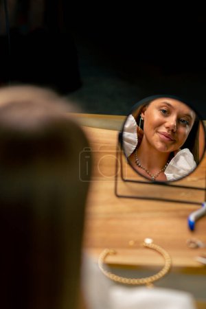 Téléchargez les photos : Portrait jeune belle aiguille essaie sur une perle collier exhibe elle-même dans le miroir artisanat production passe-temps beauté gros plan - en image libre de droit