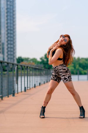 Téléchargez les photos : Danse de rue Sexy jeune femme en forme de talons talons dansant talons dans la rue dans la ville passe-temps mode de vie actif séduction - en image libre de droit