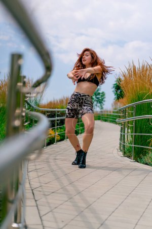 Téléchargez les photos : Portrait de danse de rue sexy jeune femme en talons talons dansant talons dans la rue dans la ville passe-temps mode de vie actif séduction - en image libre de droit