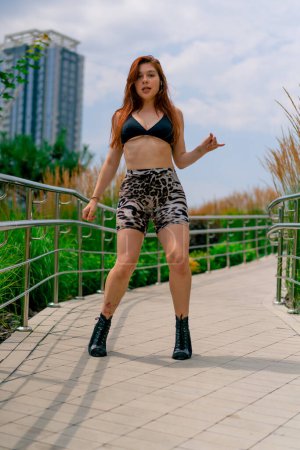 Téléchargez les photos : Danse de rue Sexy jeune femme en forme de talons talons dansant talons dans la rue dans la ville passe-temps mode de vie actif - en image libre de droit