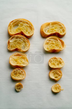 Téléchargez les photos : Croissants frais symétriquement tranchés se trouvent parfaitement plat et beau sur la table dans la boulangerie - en image libre de droit