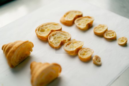 Foto de Croissants frescos en rodajas simétricas se encuentran perfectamente plana y hermosa sobre la mesa en la panadería - Imagen libre de derechos