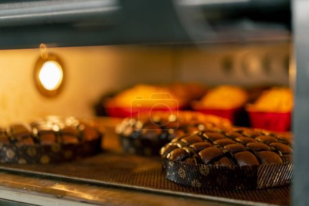 Téléchargez les photos : Plan rapproché de pain chaud fraîchement cuit debout sur une plaque de cuisson et en cours de finition au four sur - en image libre de droit