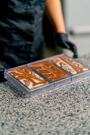 Téléchargez les photos : Une chocolatière professionnelle mélange différents types de chocolat pour préparer du chocolat naturel - en image libre de droit