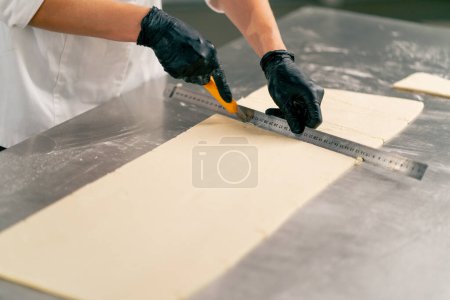 Photo for Close-up shot of a female chef's hands carefully kneading dough for preparing and baking bread in a bakery - Royalty Free Image