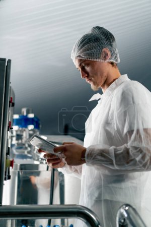 Foto de Primer plano de un tecnólogo profesional con una tableta comprobando el proceso de fermentación del vino - Imagen libre de derechos