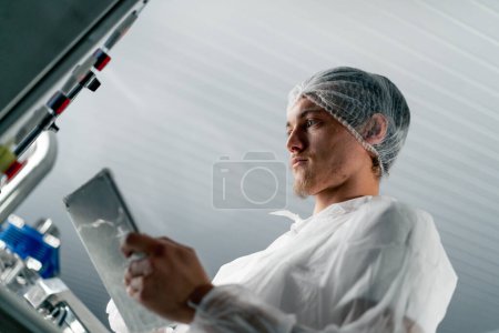 Foto de Primer plano de un tecnólogo profesional con una tableta comprobando el proceso de fermentación del vino - Imagen libre de derechos