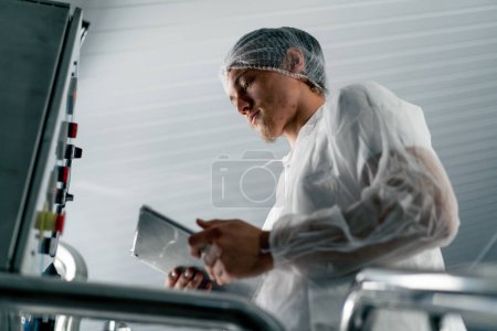 Photo for Close-up shot of a professional technologist with a tablet checking the wine fermentation process - Royalty Free Image