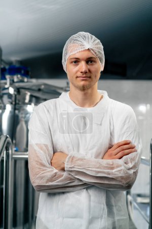 Foto de Retrato de un tecnólogo serio con uniforme especial parado en una cervecería con los brazos cruzados sobre el pecho y mirando a la cámara - Imagen libre de derechos