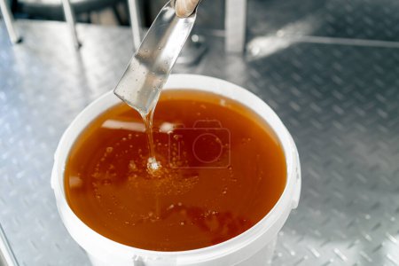 Foto de Top shot de una cuchara de metal especial mezclando miel líquida natural que fluye de nuevo en un tazón grande - Imagen libre de derechos