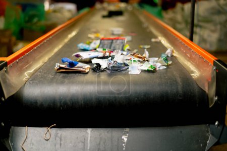 Foto de Un primer plano de plástico usado y basura de papel se encuentra en la línea de clasificación de una estación de reciclaje de residuos - Imagen libre de derechos