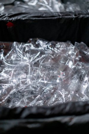 Foto de Una pila de botellas de plástico transparentes utilizadas se encuentran en un recipiente especial para plástico en una estación de reciclaje de residuos - Imagen libre de derechos