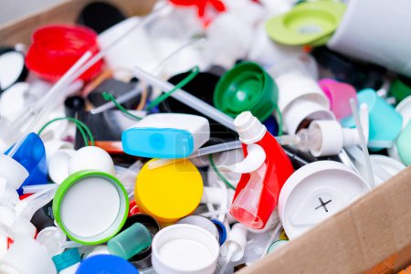 Foto de Primer plano de tapas multicolores de botellas usadas almacenadas en una estación de clasificación de reciclaje y eliminación de residuos - Imagen libre de derechos