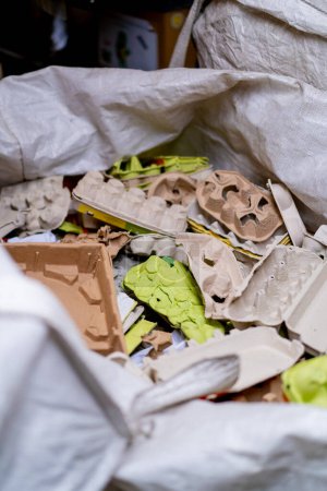 Foto de Primer plano de bandejas de huevo desechadas en una bolsa de basura grande para materiales de papel desechados en una estación de clasificación de residuos - Imagen libre de derechos
