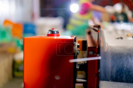 Foto de Botón rojo grande para encender y apagar el movimiento de la correa en una línea de clasificación de residuos en una fábrica - Imagen libre de derechos