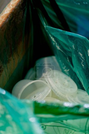 Foto de Primer plano de contenedores de plástico transparente se encuentran en una bolsa de basura en un recipiente de clasificación de plástico - Imagen libre de derechos
